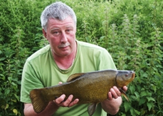 Bailiff Dave Barry with an average sized tench while carp fishing on ASL in 2012.